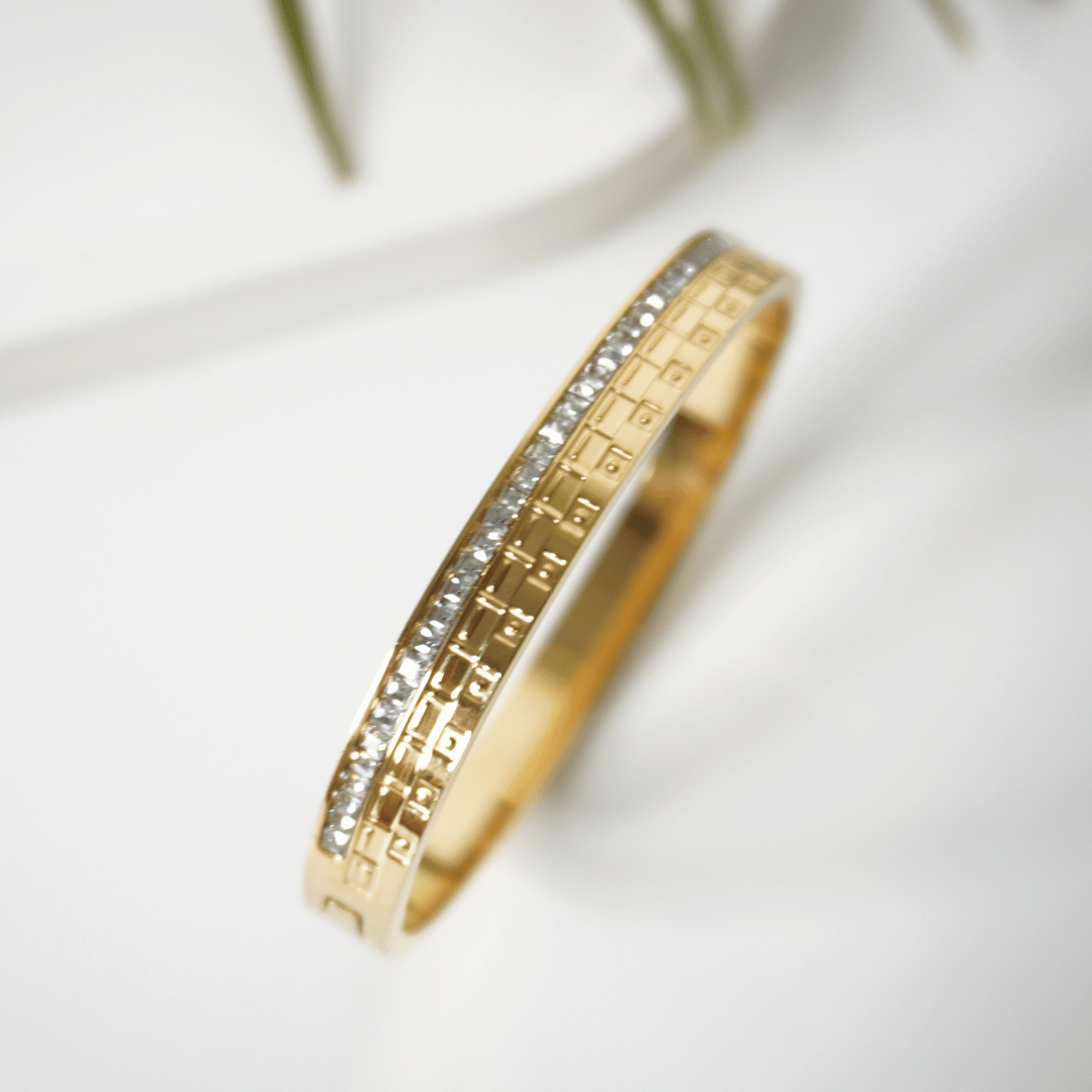 Gold ring with diamond accents on a light background